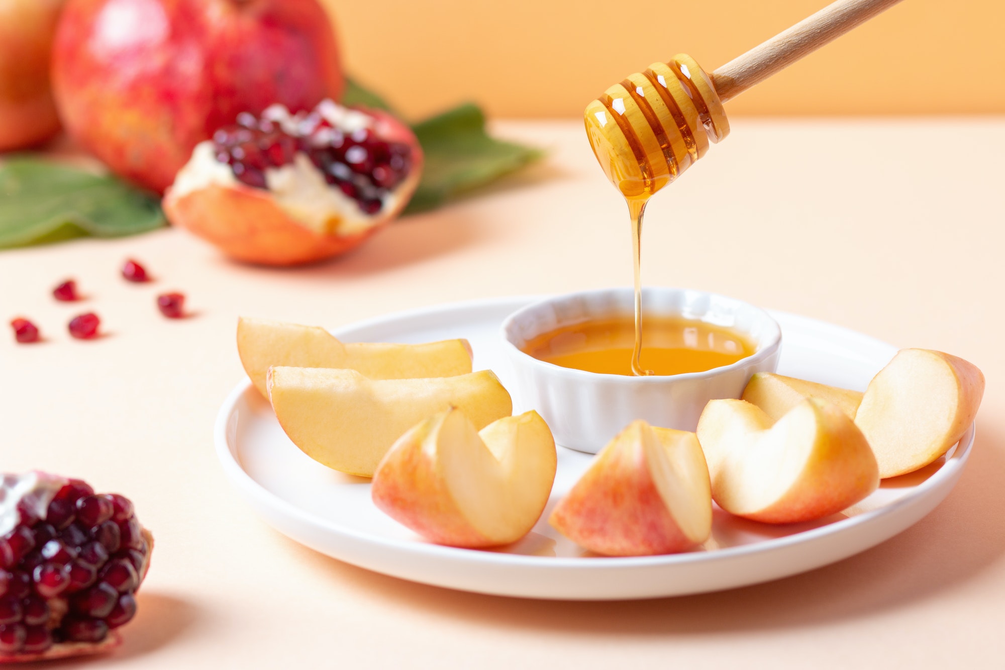 Closeup of plate with apples and honey for Jewish holiday Rosh Hashanah